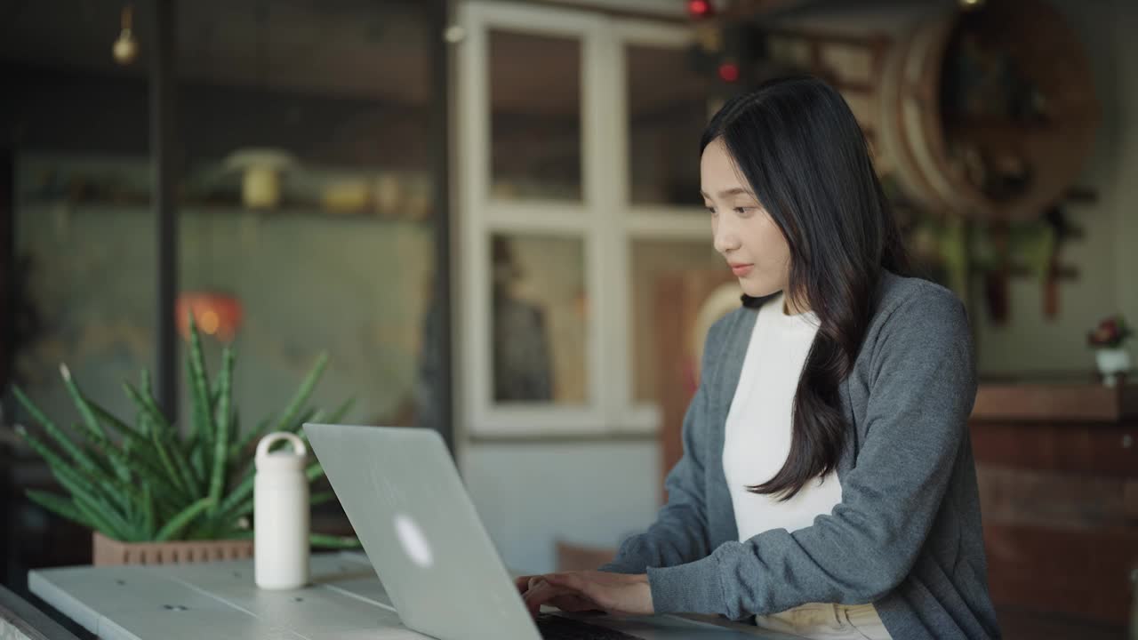 一位年轻的亚洲女性在家里使用笔记本电脑视频素材