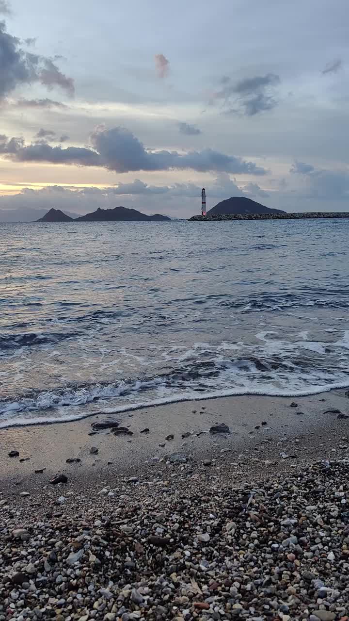 日落时的海景。海岸上的灯塔。海滨小镇Turgutreis和壮观的日落。社交媒体的垂直视频。视频素材