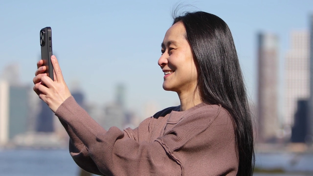 亚洲女子用手机拍城市风景视频素材