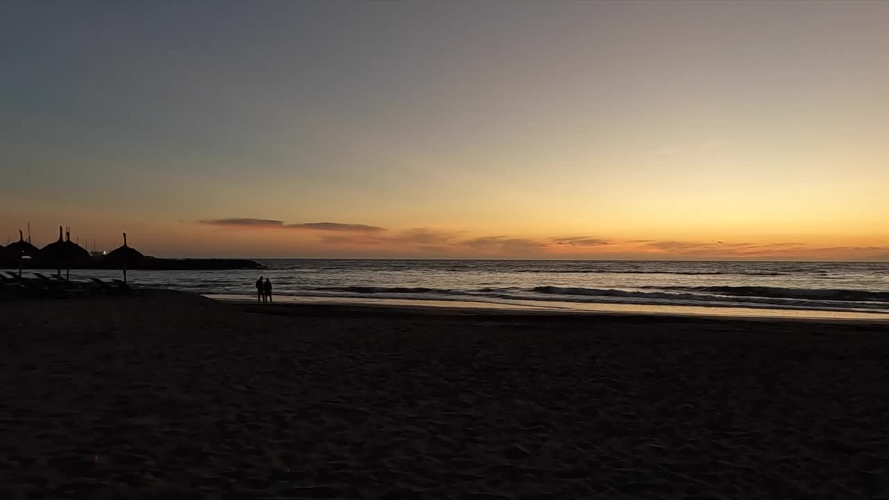 浪漫的情侣在海滩上享受美丽的日落视频素材