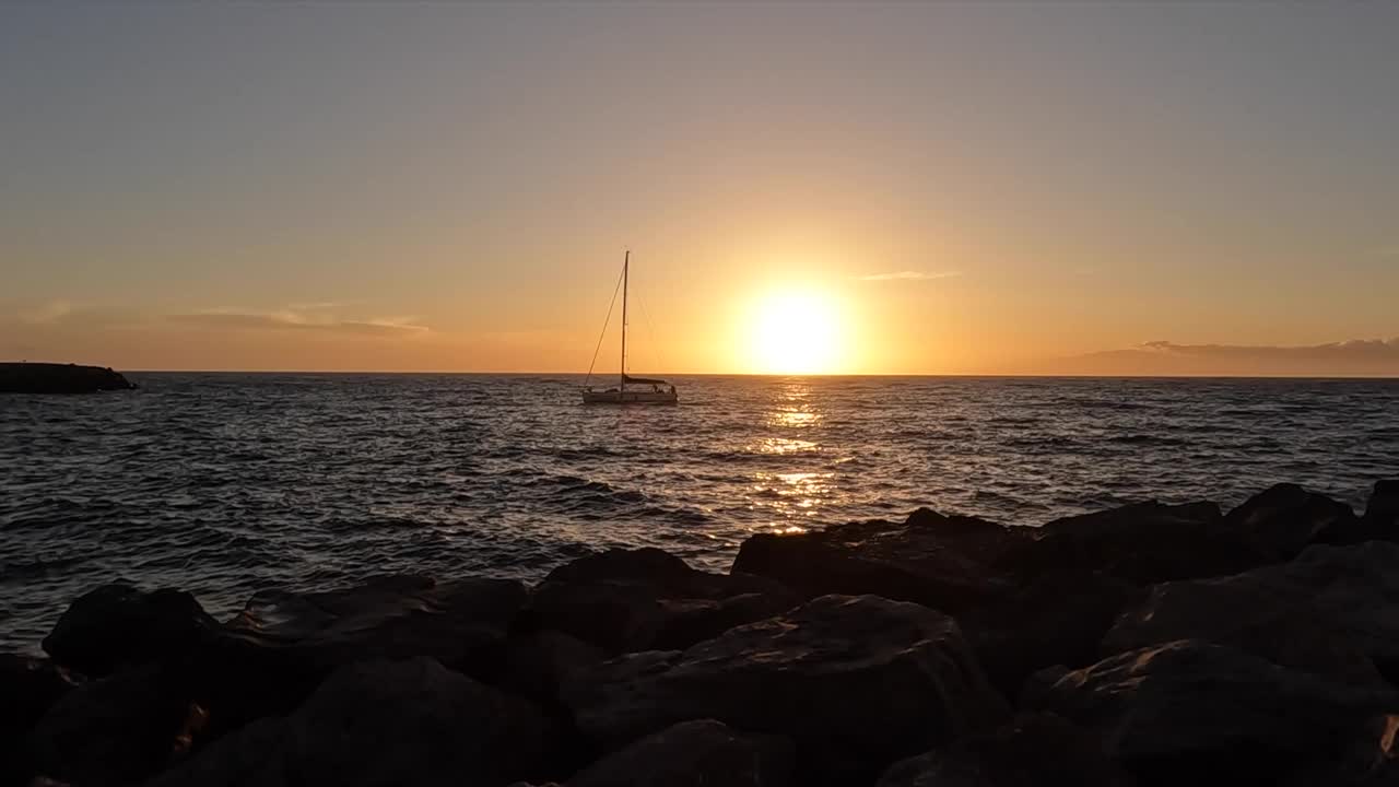 美丽的日落在特内里费岛南部的海滩，日落和船在地平线上视频素材