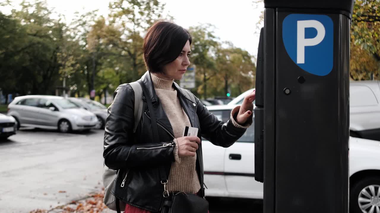 女人通过停车计时器付停车费视频素材