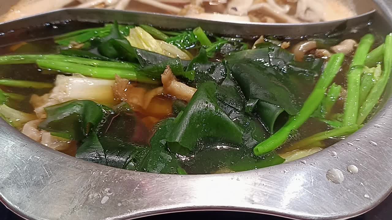 用蔬菜和肉在火锅里煮涮肉或寿喜烧。亚洲美食视频下载