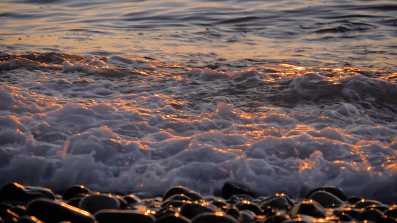 慢镜头——海浪冲击卵石滩——近距离拍摄视频素材