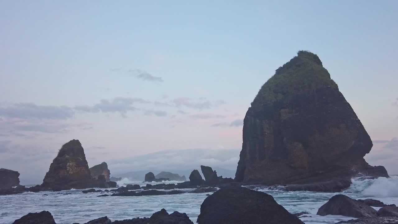 在东爪哇的帕uma海滩，海浪冲击着岩石视频素材