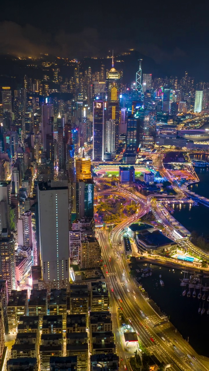 夜晚的香港城市天际线，充满活力的街道，城市灯光反射在港口上。视频素材