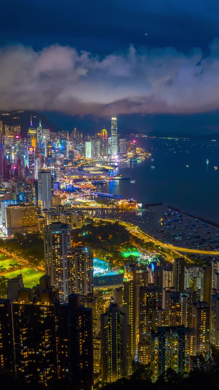 夜晚的香港城市天际线，充满活力的街道，城市灯光反射在港口上。视频素材