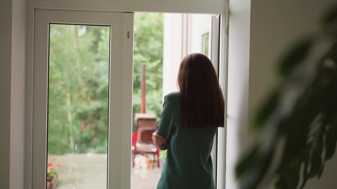 沮丧的女人望着窗外的雨视频素材