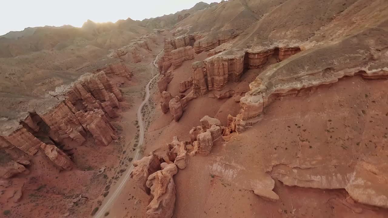 FPV无人机俯冲拍摄山地岩石地质地层石质结构速度坠落峡谷阳光自然鸟瞰图。悬崖地形电影海拔沙漠山谷景观。视频素材