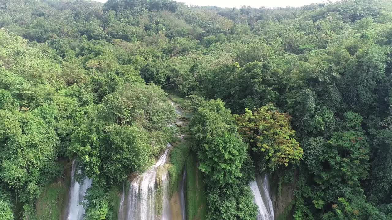 鸟瞰瀑布在热带雨林与岩石和蓝绿色的池塘视频素材