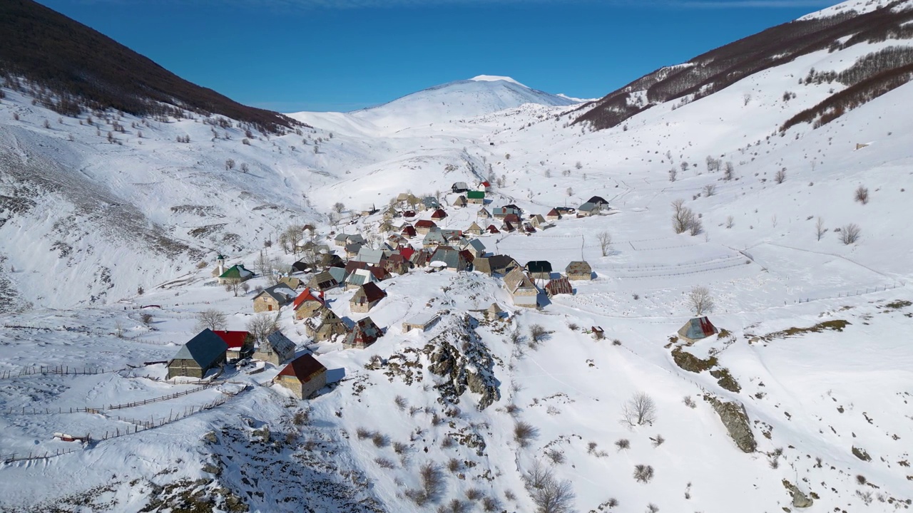 冬季山村的无人机鸟瞰图。雪白的风景和登山者的生活方式。波斯尼亚和黑塞哥维那的Lukomir村。视频下载