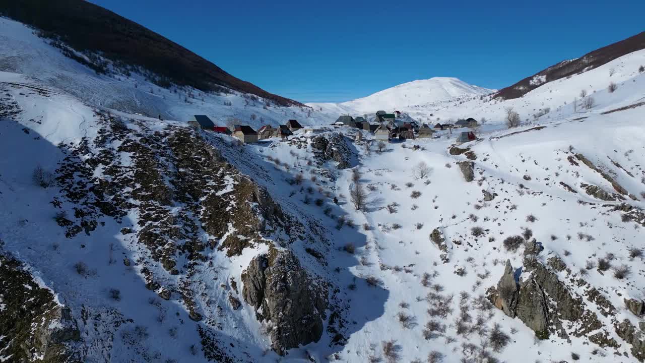 冬季山村的无人机鸟瞰图。雪白的风景和登山者的生活方式。波斯尼亚和黑塞哥维那的Lukomir村。视频下载