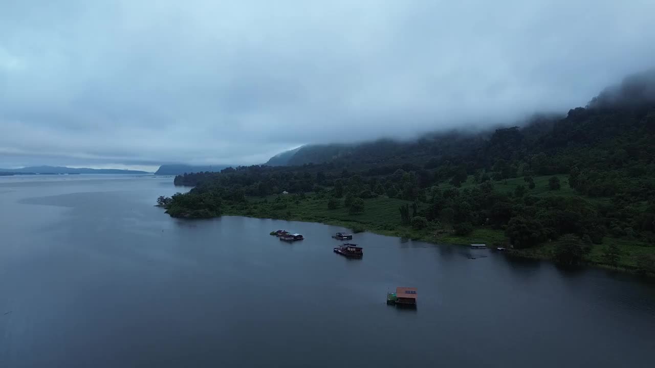 房子建在湖上的木筏上，还有雾气缭绕的山脉。视频下载