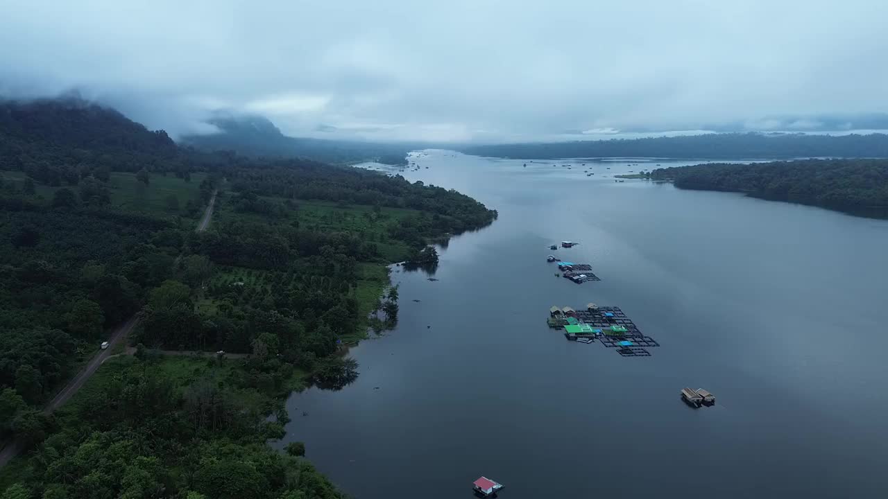 房子建在湖上的木筏上，还有雾气缭绕的山脉。视频下载