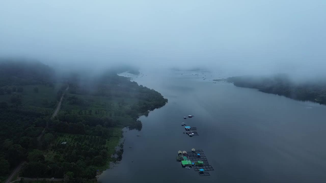 房子建在湖上的木筏上，还有雾气缭绕的山脉。视频下载