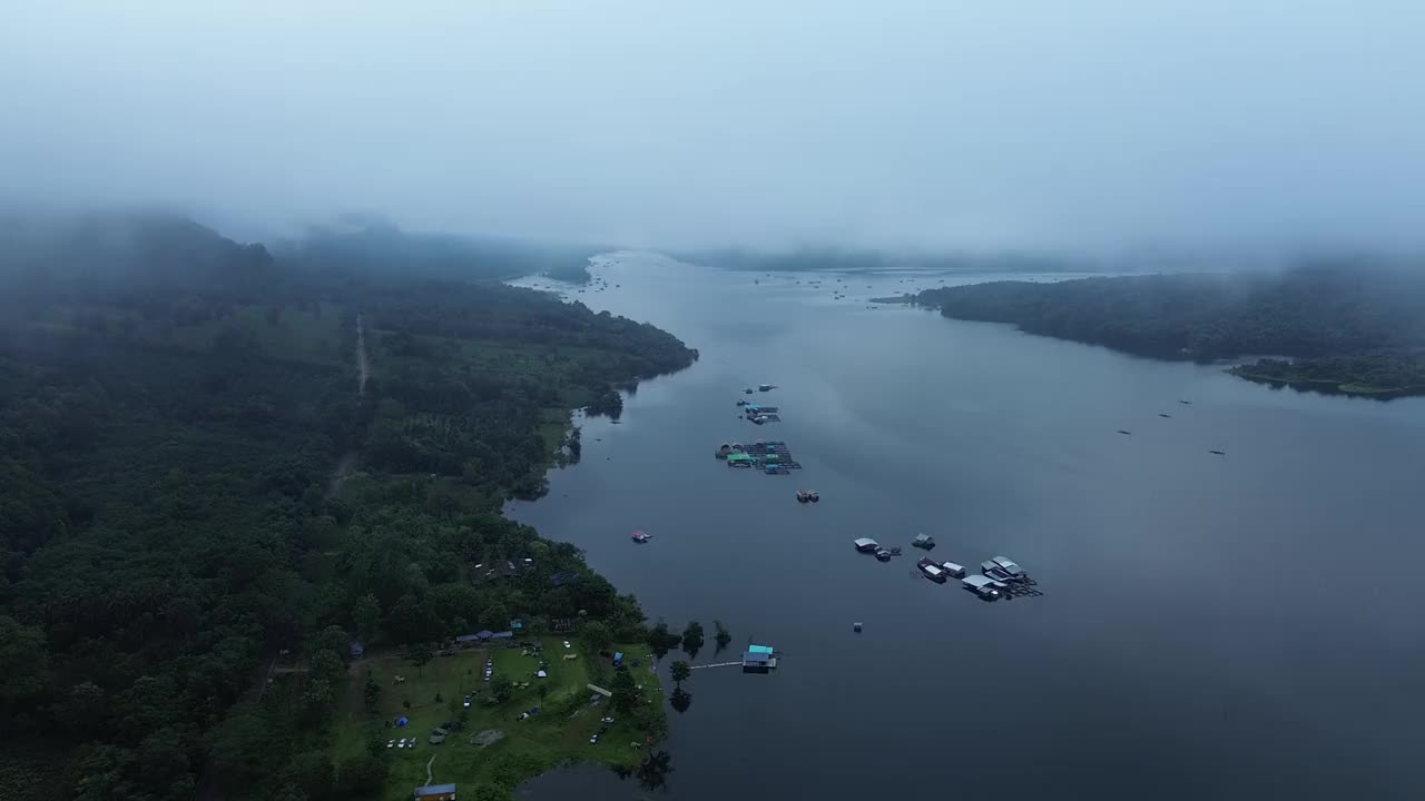 房子建在湖上的木筏上，还有雾气缭绕的山脉。视频下载