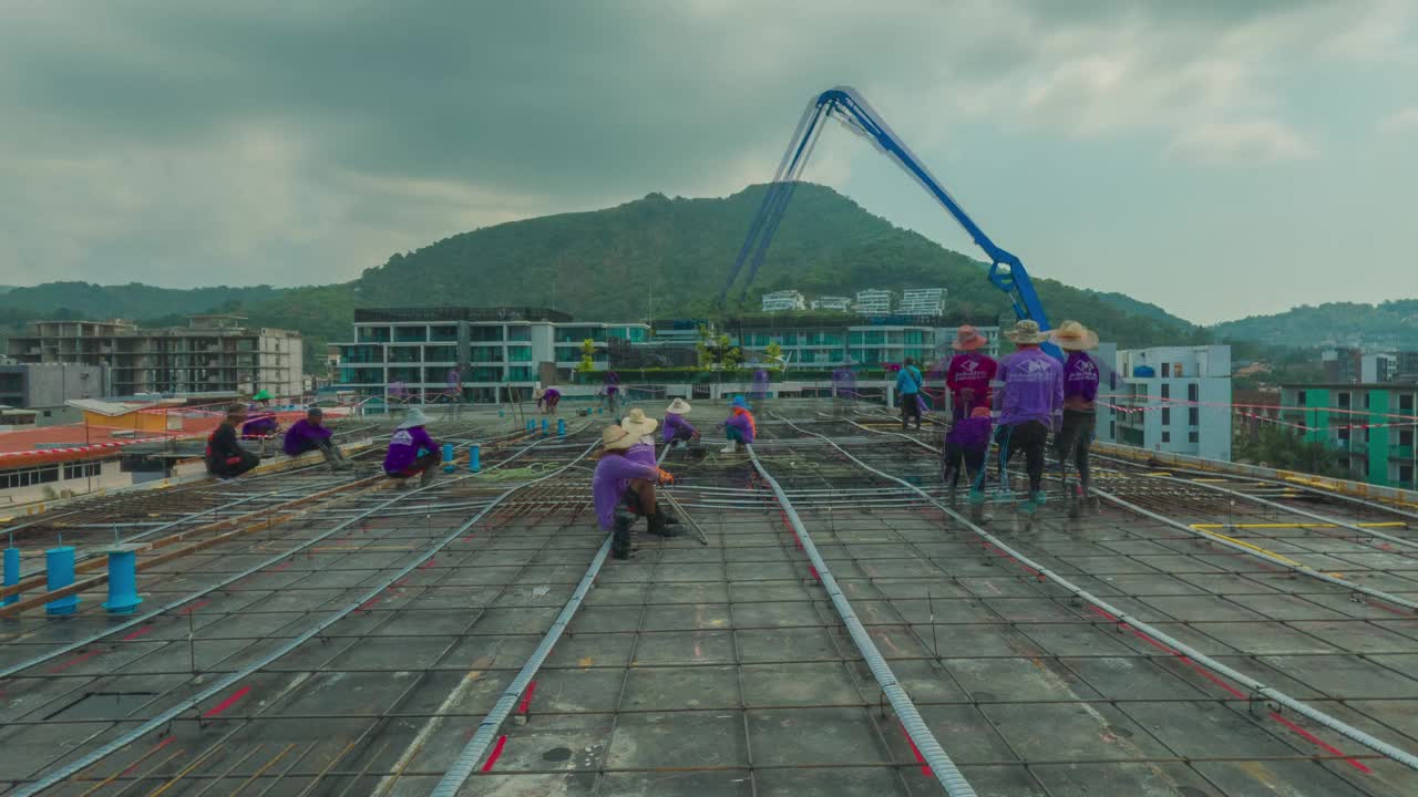 建筑工地的工人正在用混凝土泵把混凝土倒在地板上。视频素材