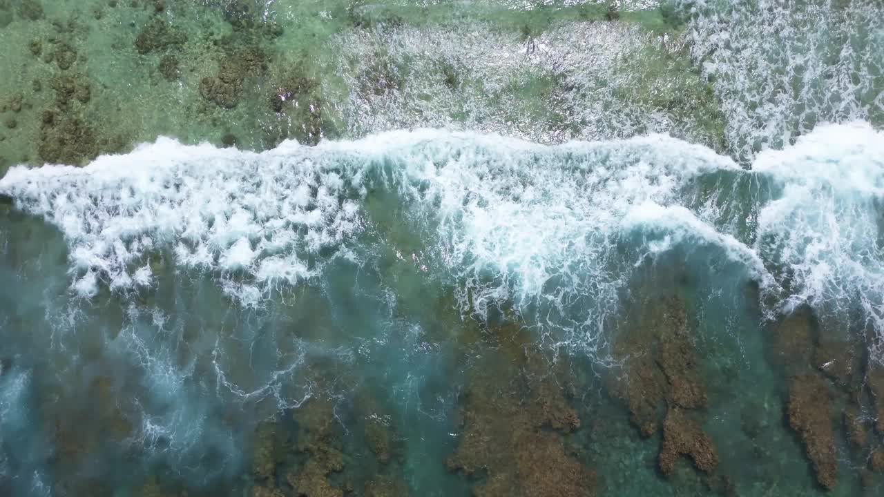 无人机拍摄的印度洋海浪在马尔代夫海滩的珊瑚礁上。视频素材