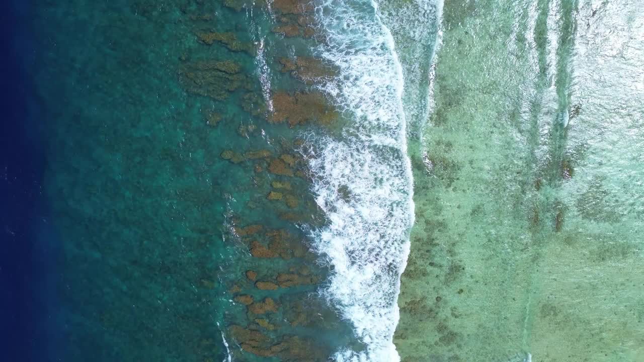 无人机拍摄的印度洋海浪在马尔代夫海滩的珊瑚礁上。视频素材