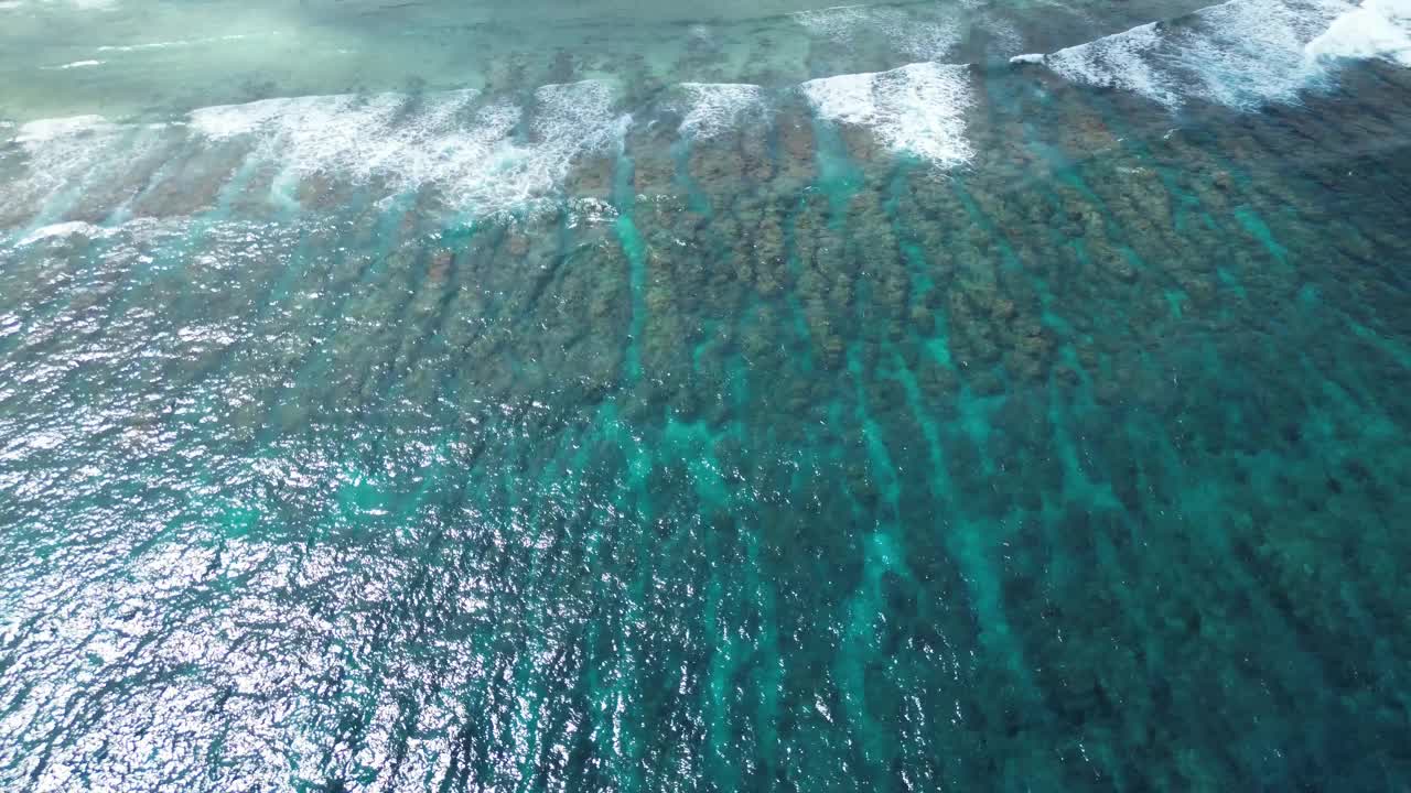 无人机拍摄的印度洋海浪在马尔代夫海滩的珊瑚礁上。视频素材