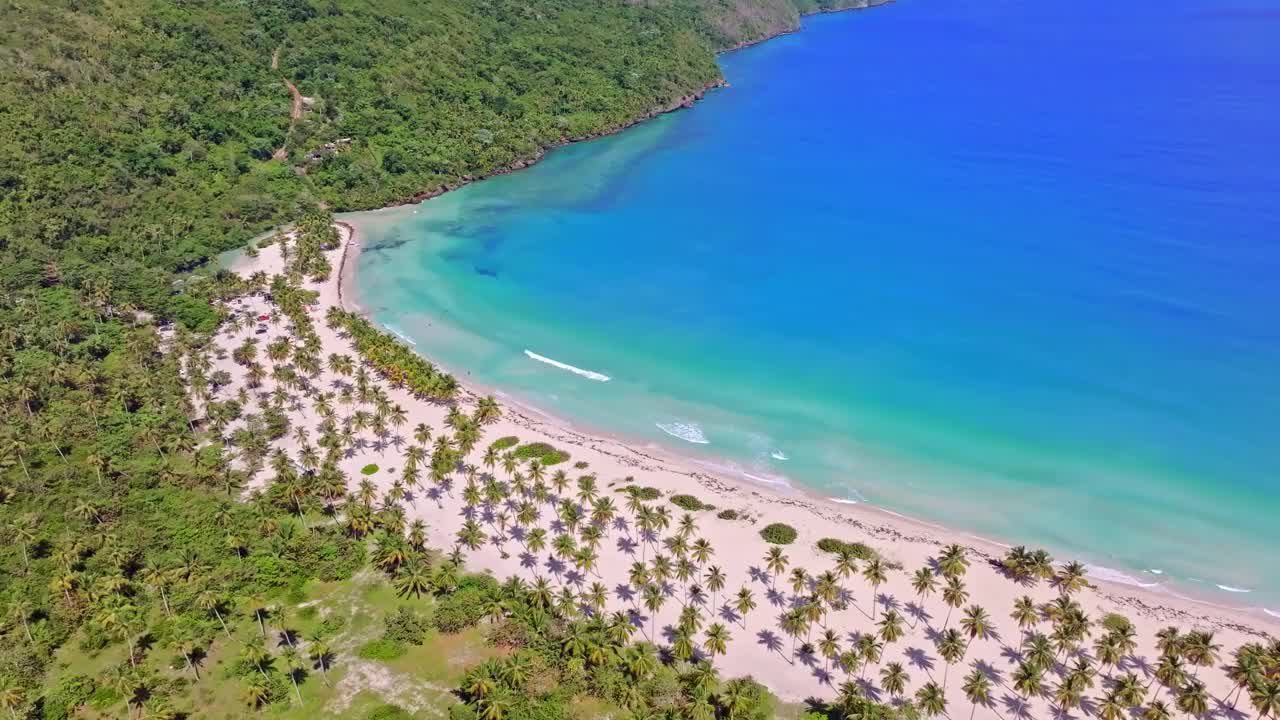 白色沙滩上的椰子树，绿松石般的海水。Playa Rincon在多米尼加共和国的萨马纳。空中倾斜视频素材