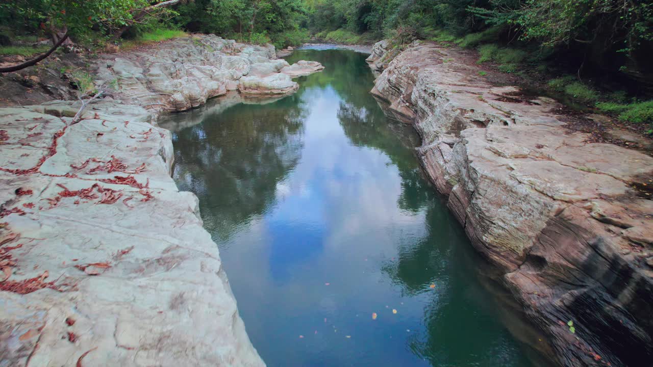 宁静的河流流经卡琼斯德查梅，巴拿马，岩石堤岸和茂密的树木视频素材