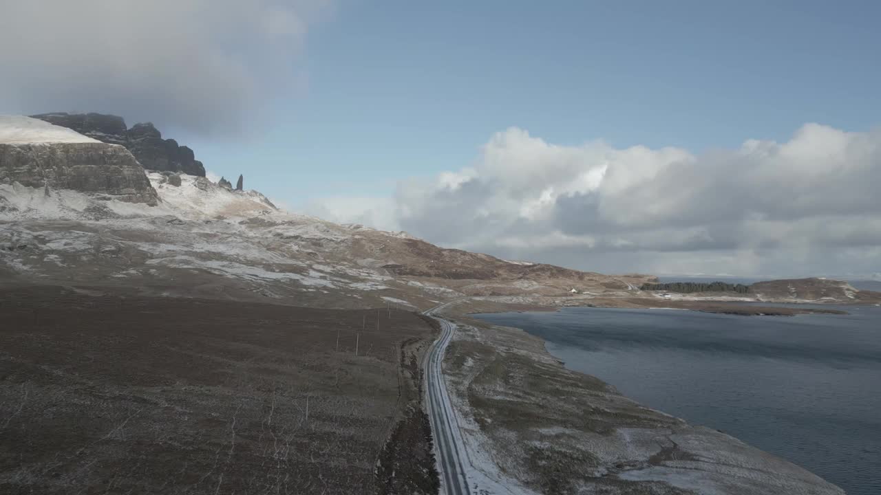 蜿蜒的道路附近的天空桥与风景秀丽的韦尔地区在苏格兰，雪山和清澈的水混合视频素材