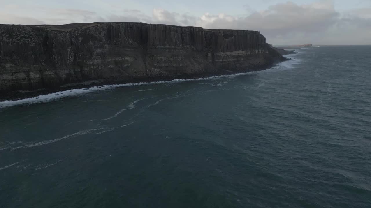 鸟瞰图，苏格兰天空中崎岖的苏格兰裙岩悬崖，海浪拍打着海岸视频素材