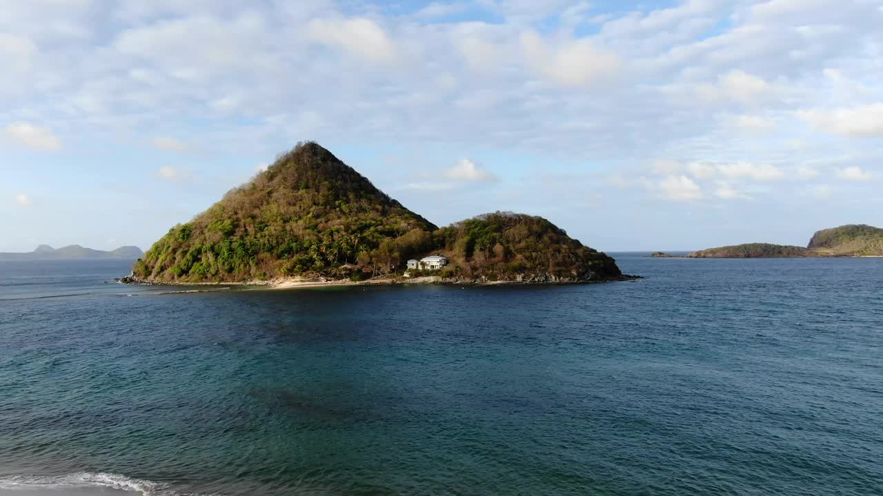 僻静的热带岛屿，郁郁葱葱的绿色植物和一所房子，蓝色的海水，宁静的氛围，日光视频素材