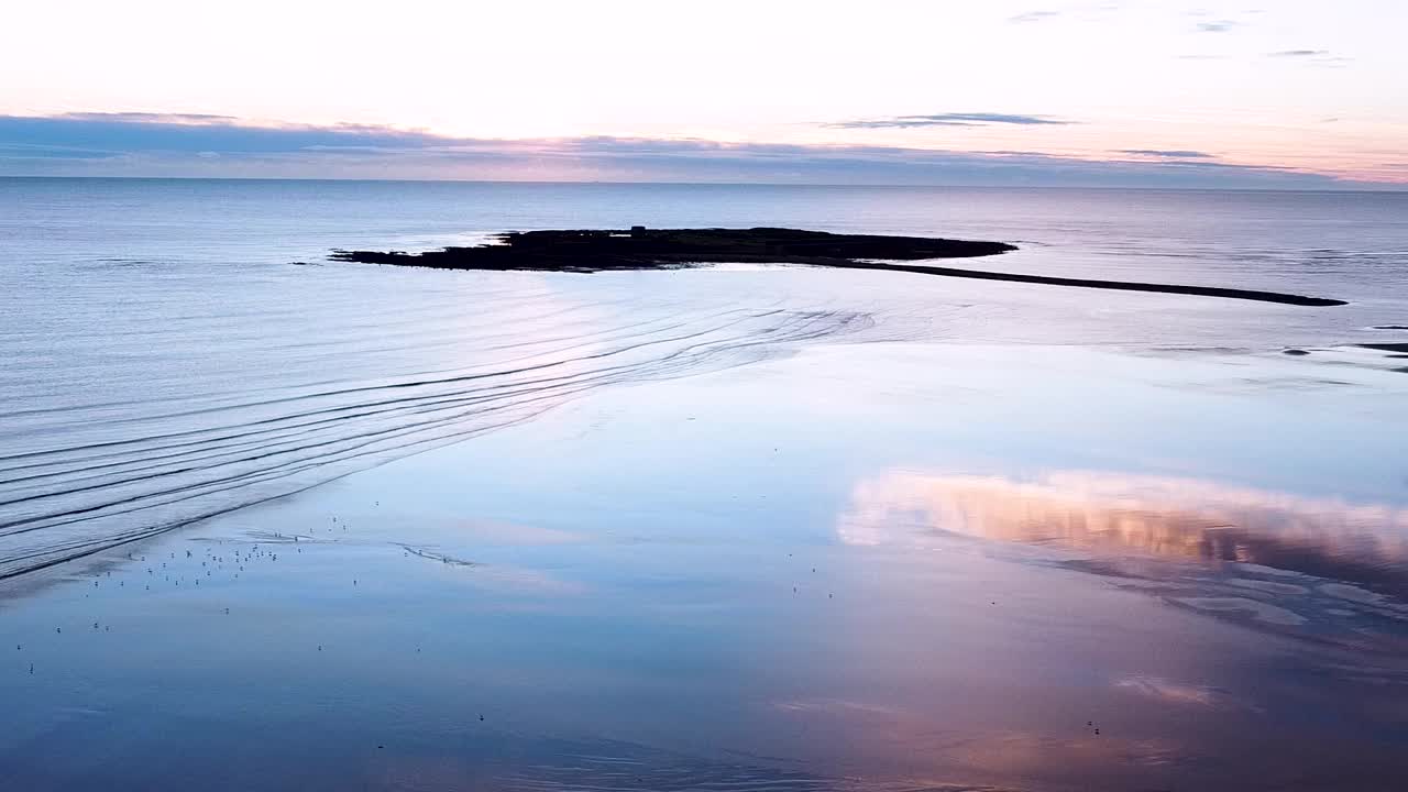 风景如画的无人机拍摄的平静的海浪卷起沙滩上的斯克里斯海滩上的日出，爱尔兰共和国视频素材