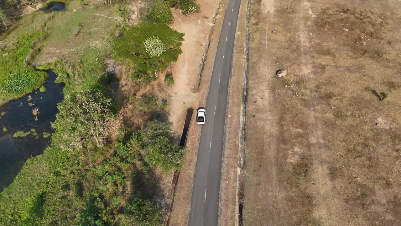 无人机拍摄鸟瞰风景，驾驶皮卡车在旱季偏僻的乡村道路上行驶视频素材