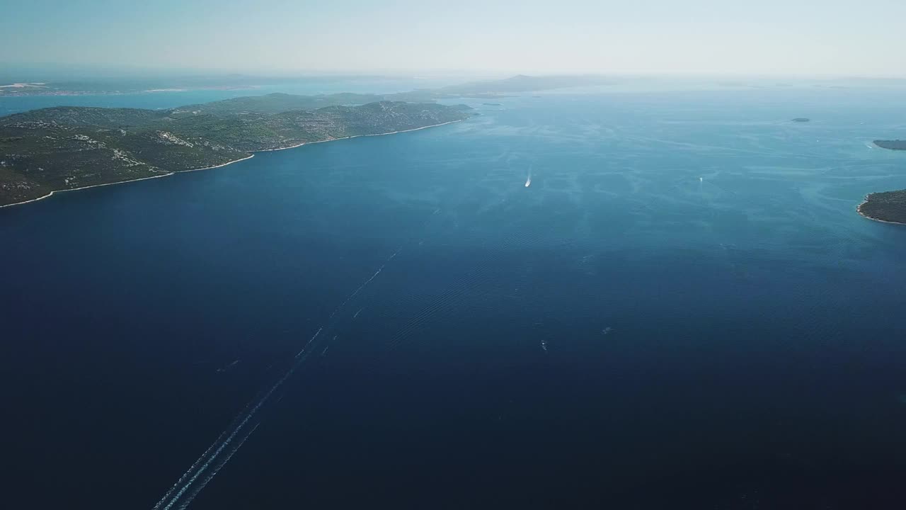 鸟瞰克罗地亚乌格扬岛上美丽的蓝色海岸线村庄。视频素材