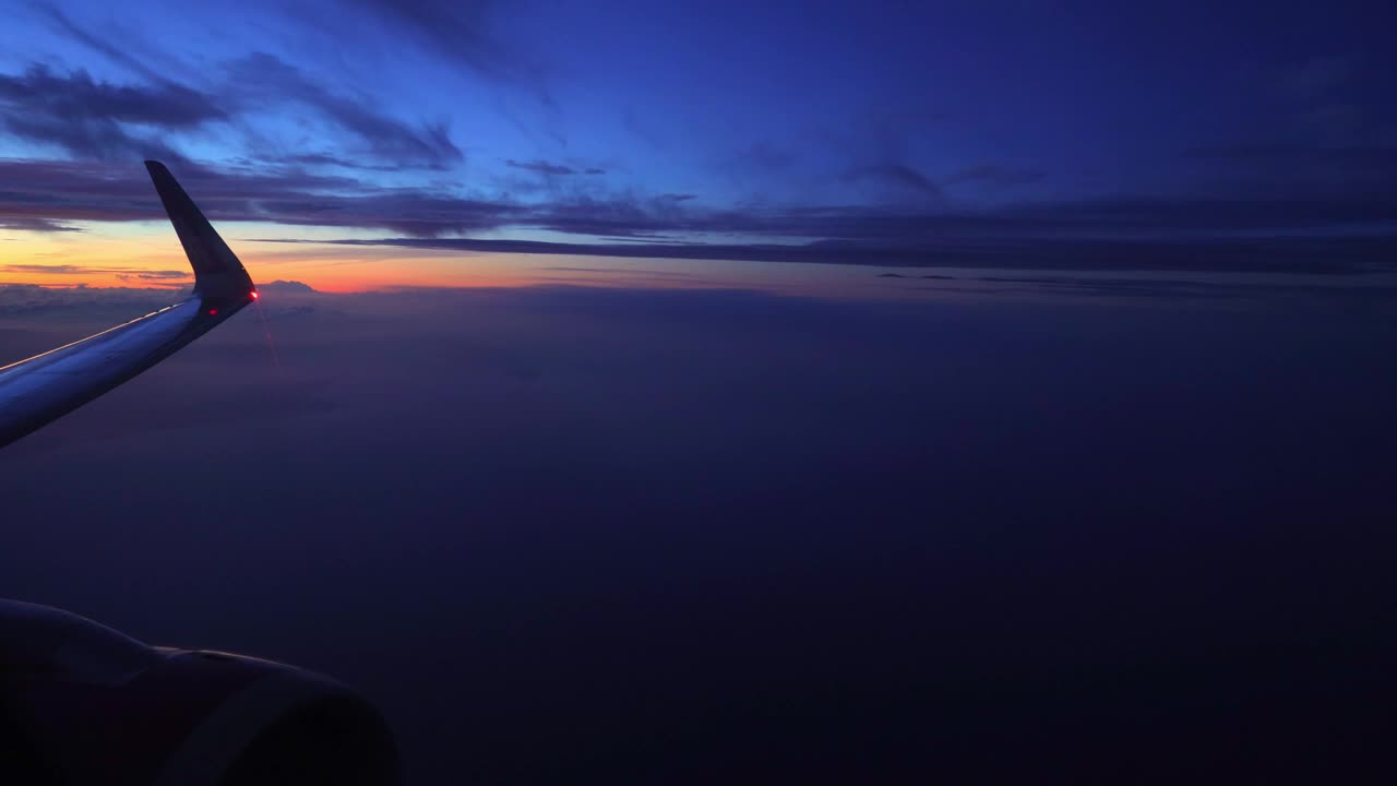 飞机在黄昏时飞过云层视频素材