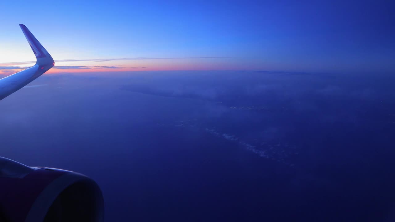 飞机在黄昏时飞过云层视频素材