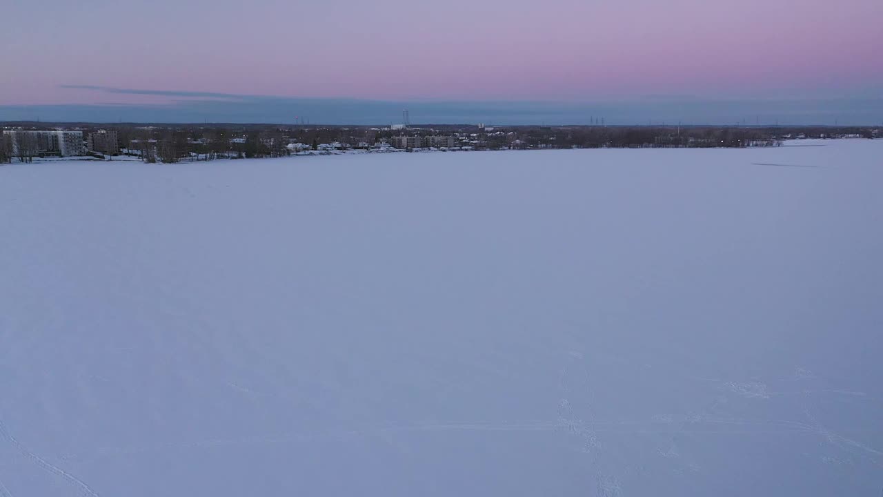 空中无人机拍摄了一名男子在冰冻的河上拉雪橇的画面视频素材