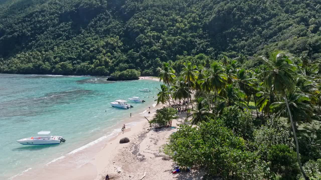 停泊的船只与游客探索风景秀丽的棕榈流苏普拉亚埃尔米塔诺。无人机。视频素材