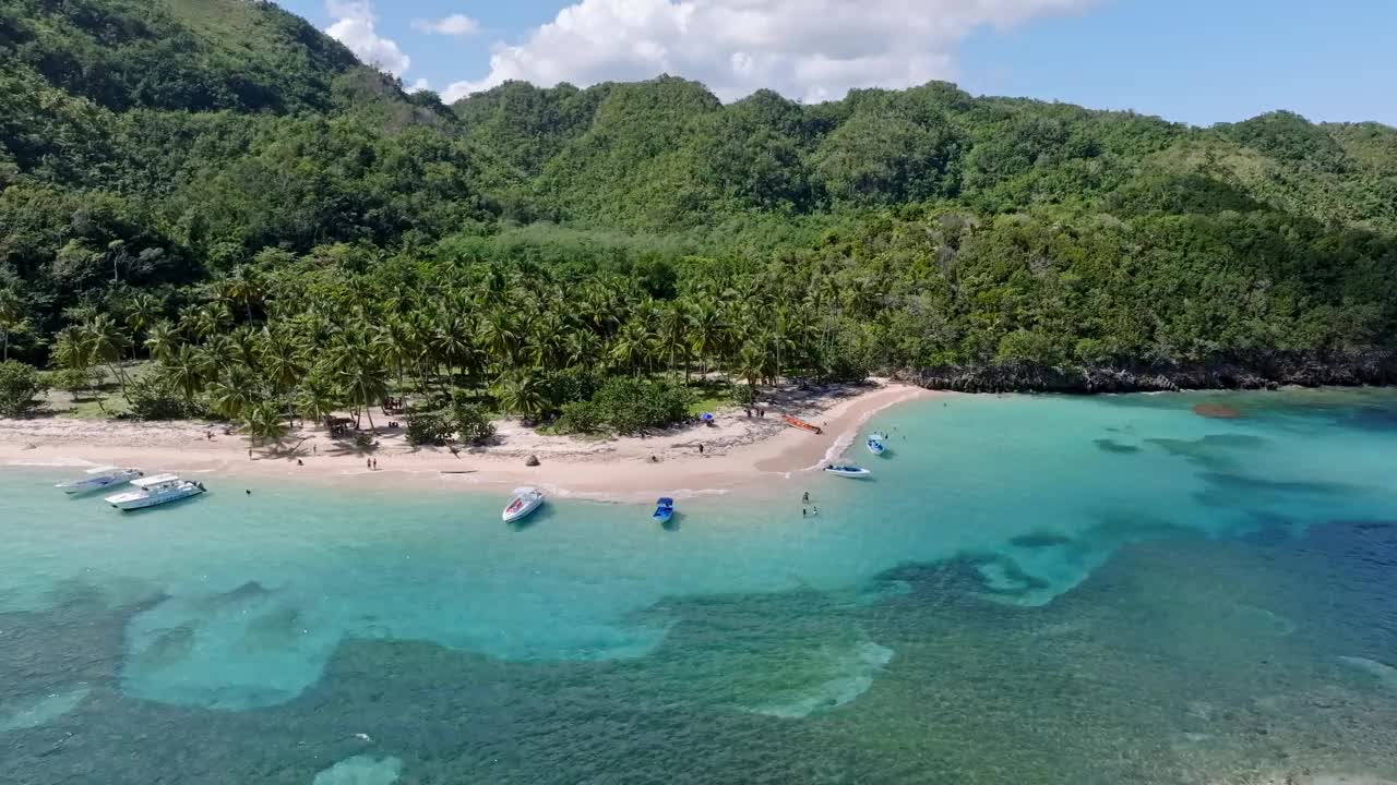 航拍弧线的旅游船只停泊在原始的普拉亚埃尔米塔诺在加勒比海视频素材