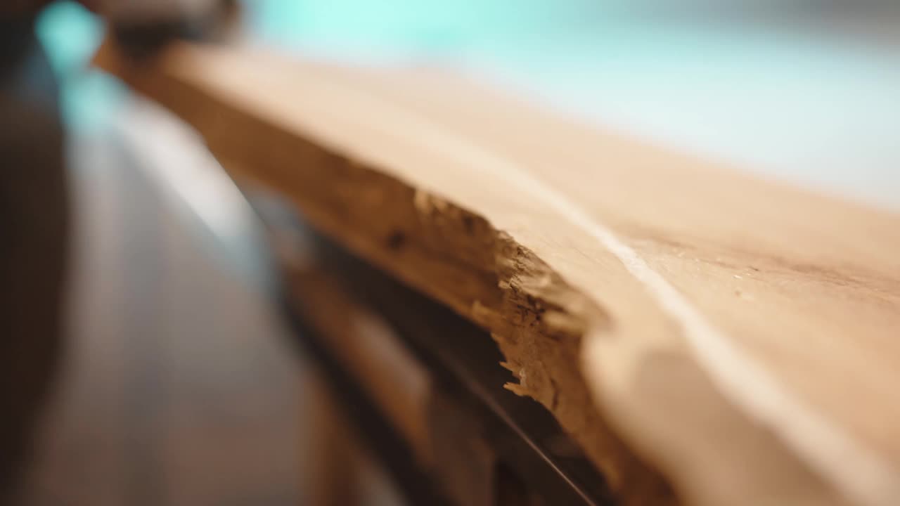 木匠用角磨机在工作台上打磨木板，沿着木板画上白色的标记线以便更好地磨边，木匠为最后的加工准备硬木。木材制造和木工工业视频素材