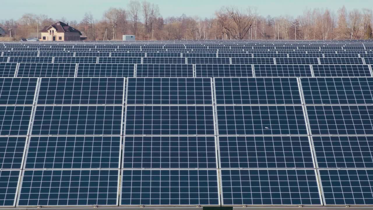 太阳能公园里的光伏太阳能电池板。绿色的草地和蓝天上的太阳能电池板。视频下载