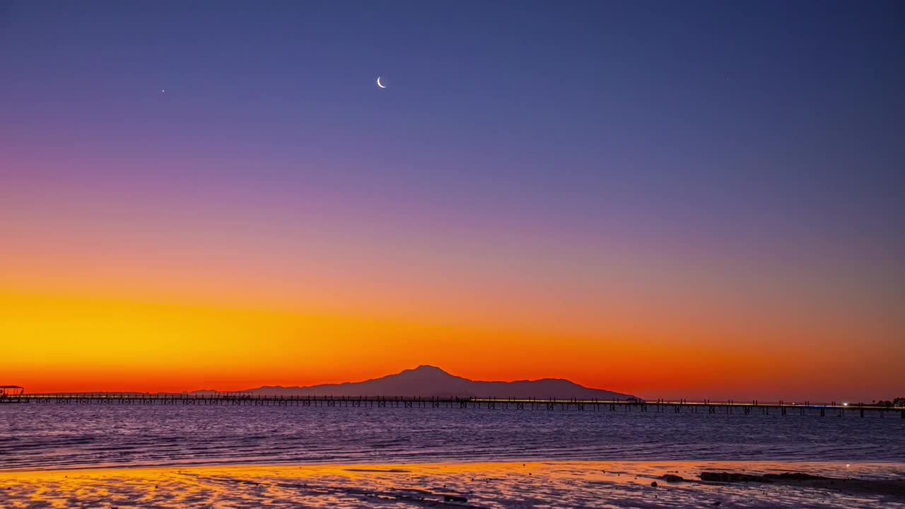 日出或日落，晴朗的天空，在海滩上无云的海水视频素材