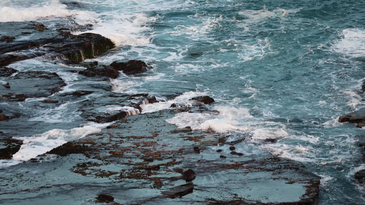 海浪冲击着岩石海岸线。慢镜头视频素材