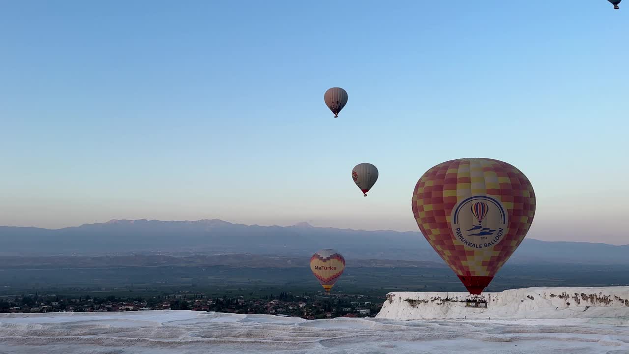 在Pamukkale，日出时热气球漂浮在露天矿物温泉上的广角镜头。视频素材