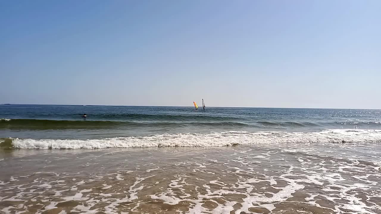 海景。在炎热的夏天，人们在海里放松和游泳。活跃的娱乐，风帆冲浪在保加利亚黑海海岸。滨海滨海的佩拉海滩。视频素材