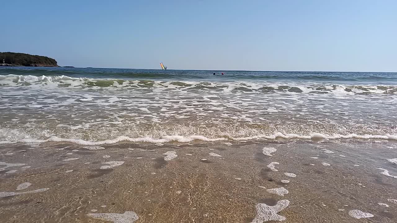 海景。在炎热的夏天，人们在海里放松和游泳。活跃的娱乐，风帆冲浪在保加利亚黑海海岸。滨海滨海的佩拉海滩。视频下载