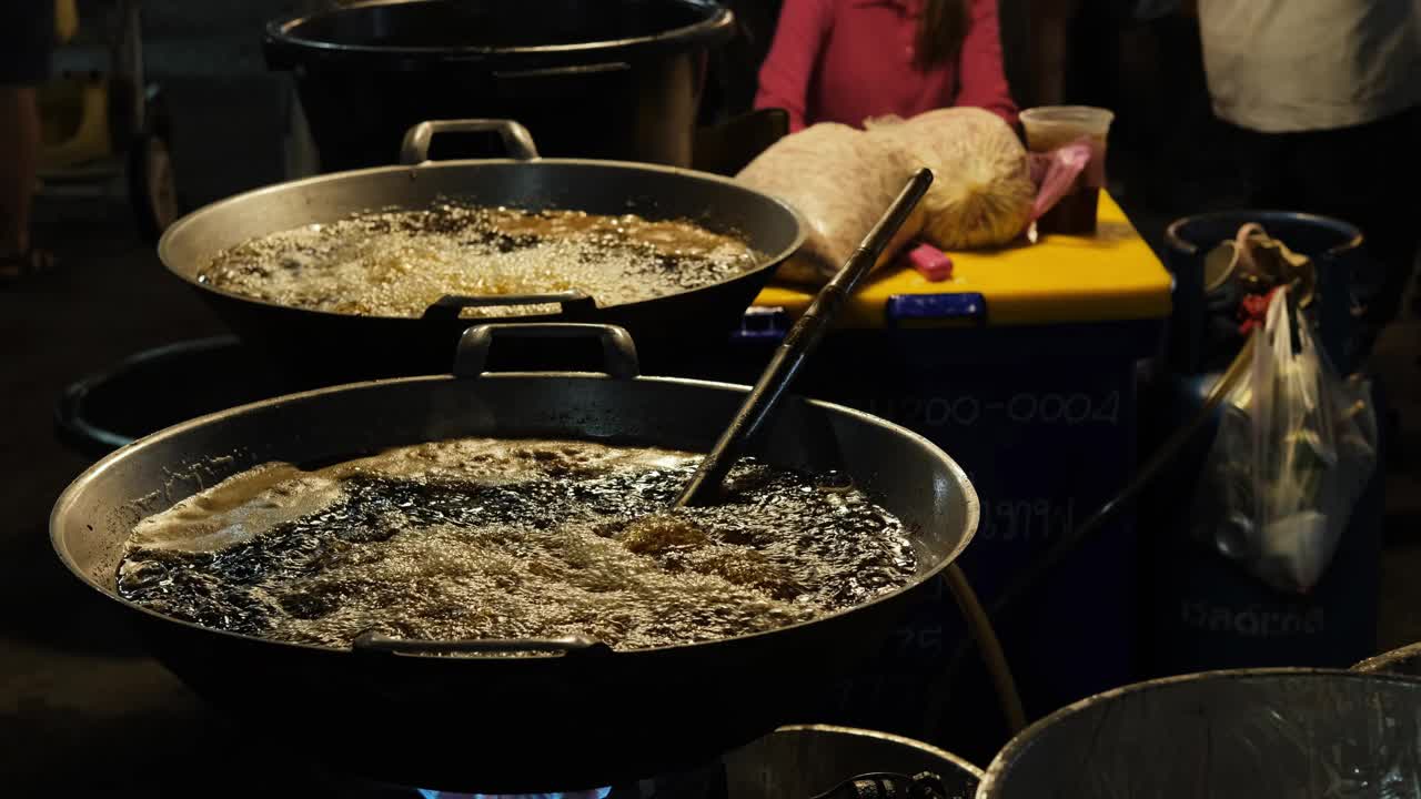 泰国夜市的大碗里有滚烫的油视频素材