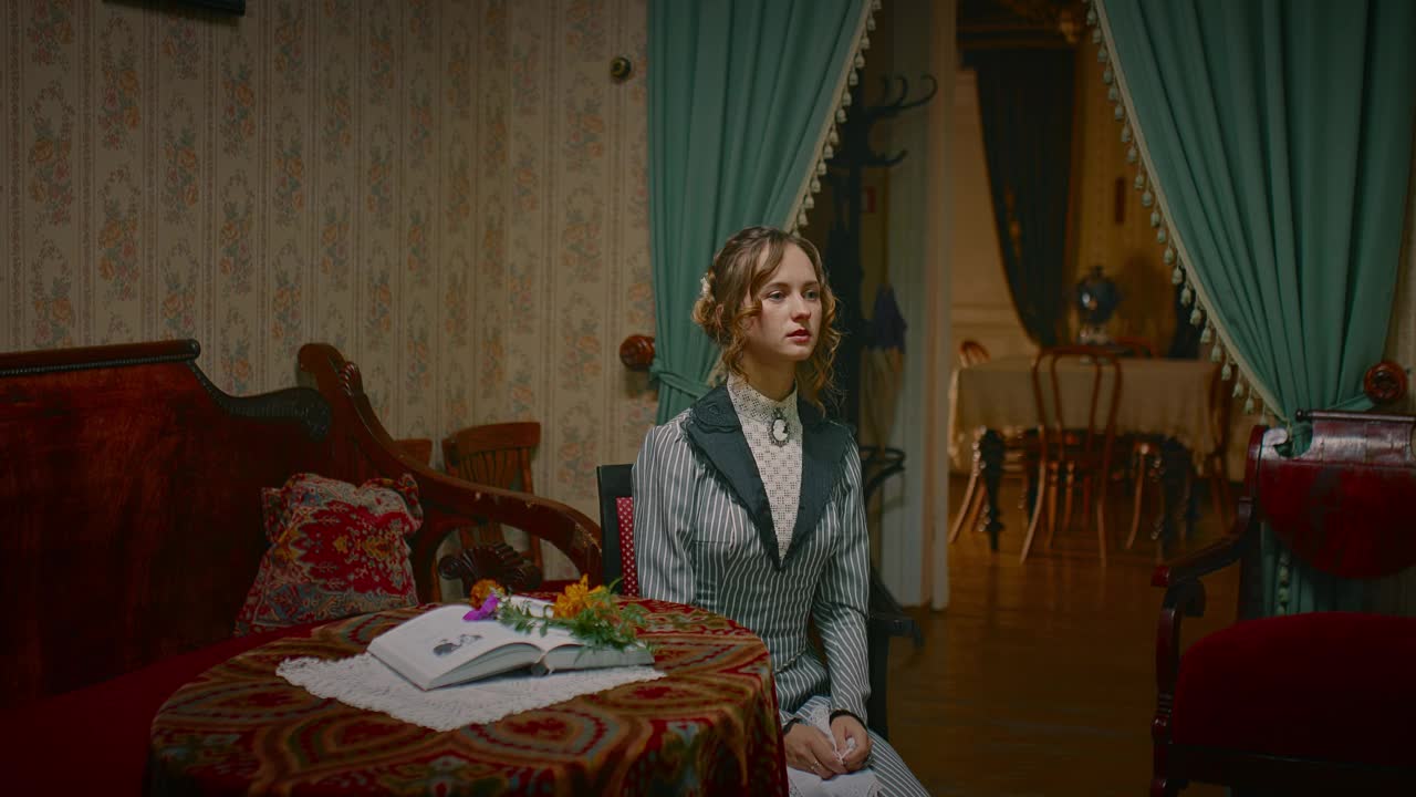 悲伤哭泣的美丽女人穿着19世纪的复古连衣裙坐在房间里，4K, Prores视频下载