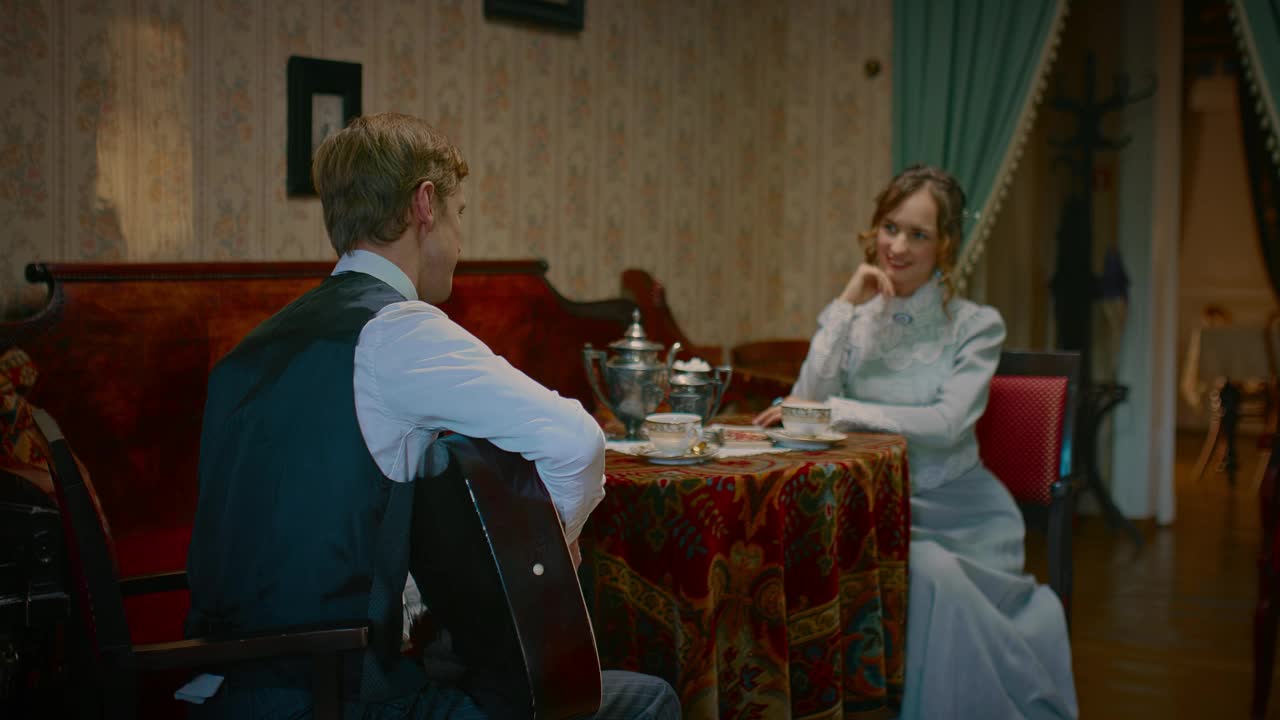 浪漫的男人在19世纪的复古房间里为美丽的女人弹吉他，4K, Prores视频下载