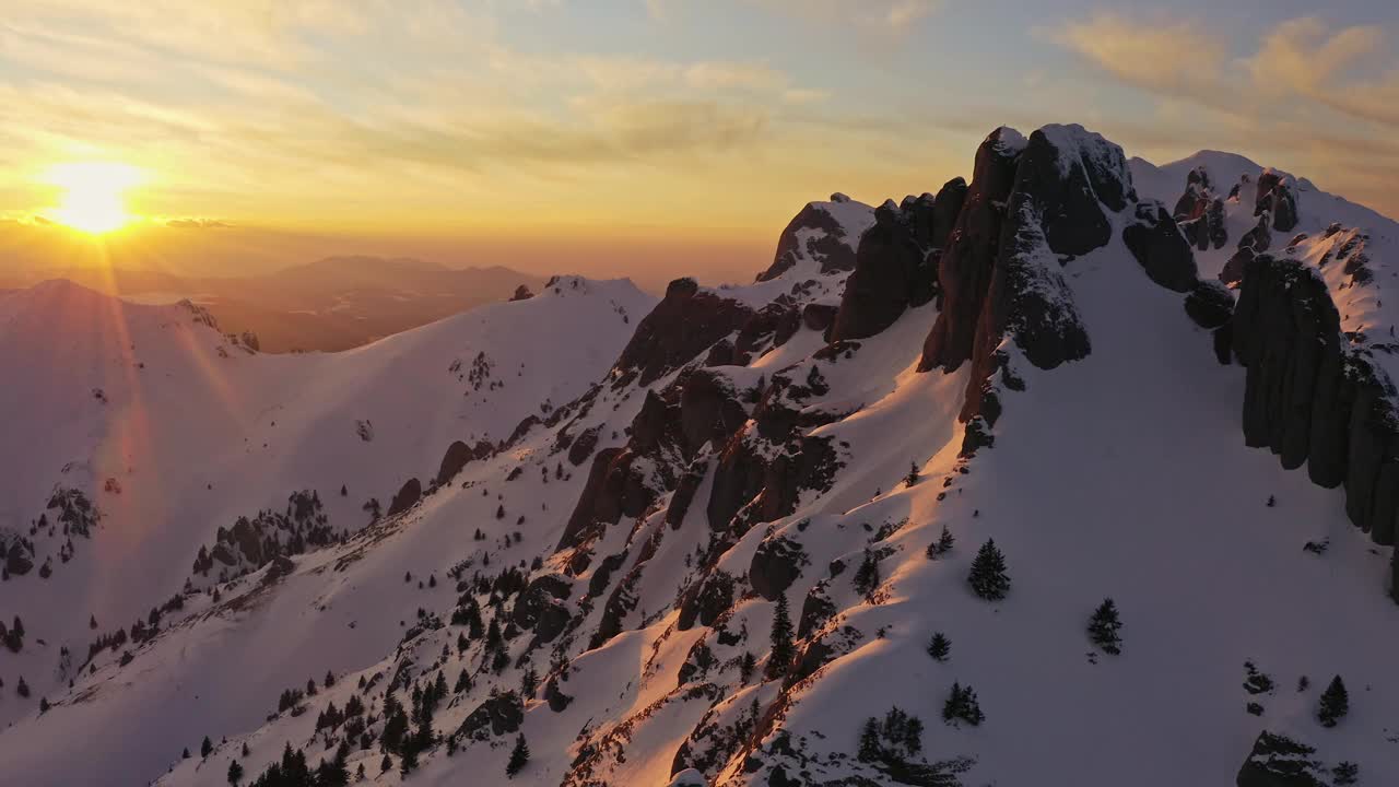 金色的夕阳洒在白雪覆盖的丘卡斯山上，投下暖色调视频素材