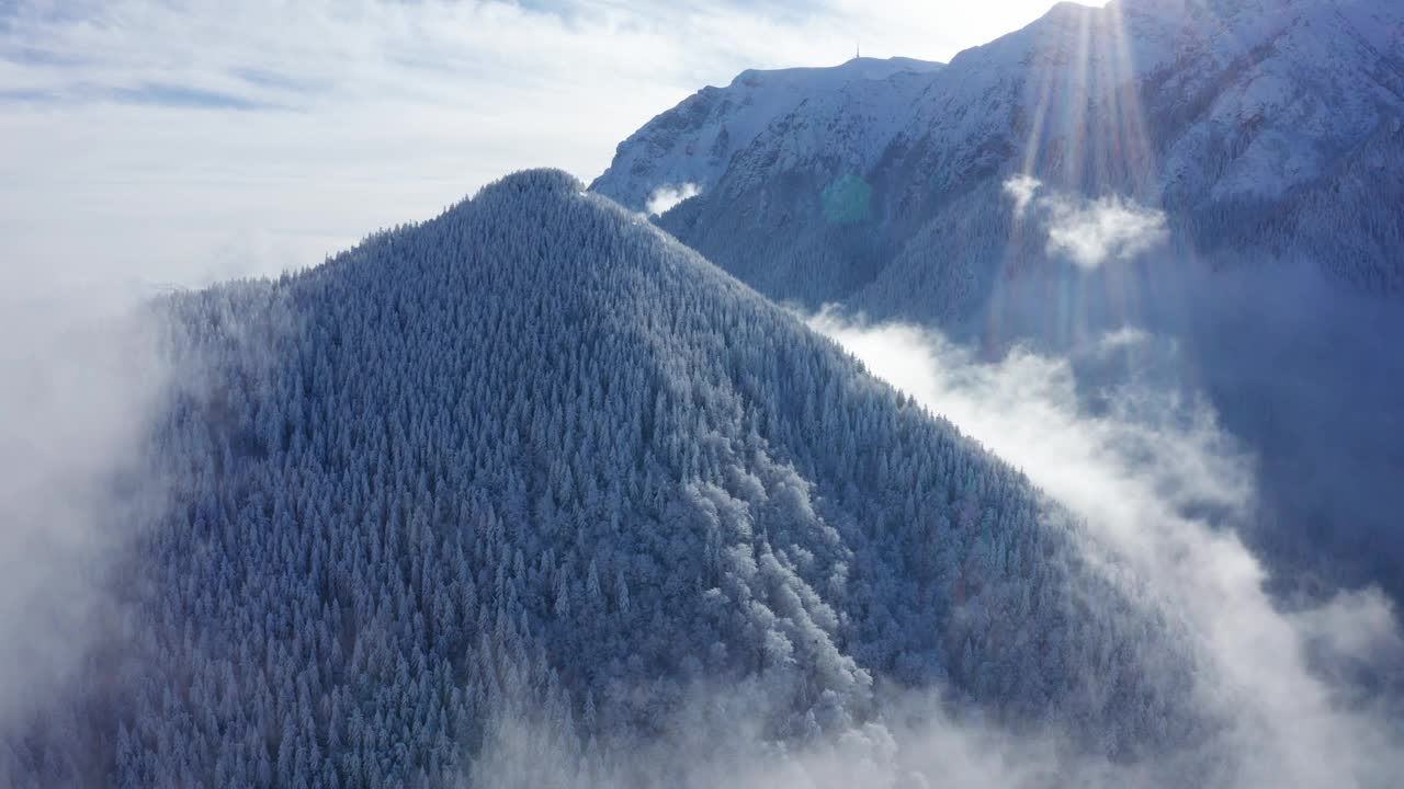 白雪覆盖的釜溪山穿过云层，闪耀着阳光视频素材