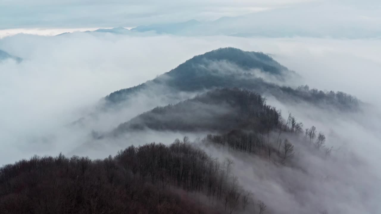 薄雾缭绕的山峰在柔云之上，安详而雄伟视频素材